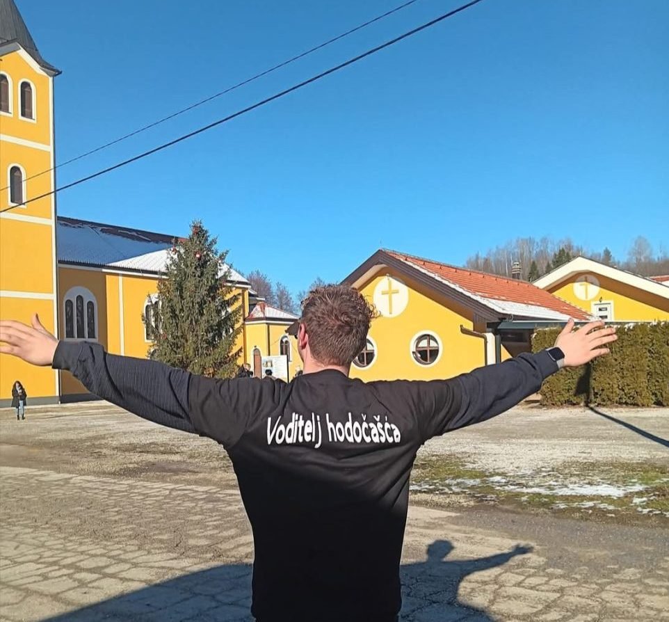 Mladić koji je okrenut prema crkvi u Šurkovcu. Vođenje hodočašća u Šurkovac uz njegovo svjedočanstvo.